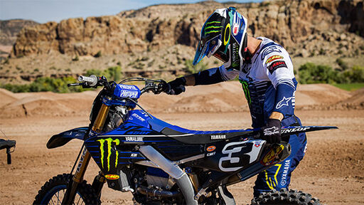 Eli Tomac walking his dirt bike