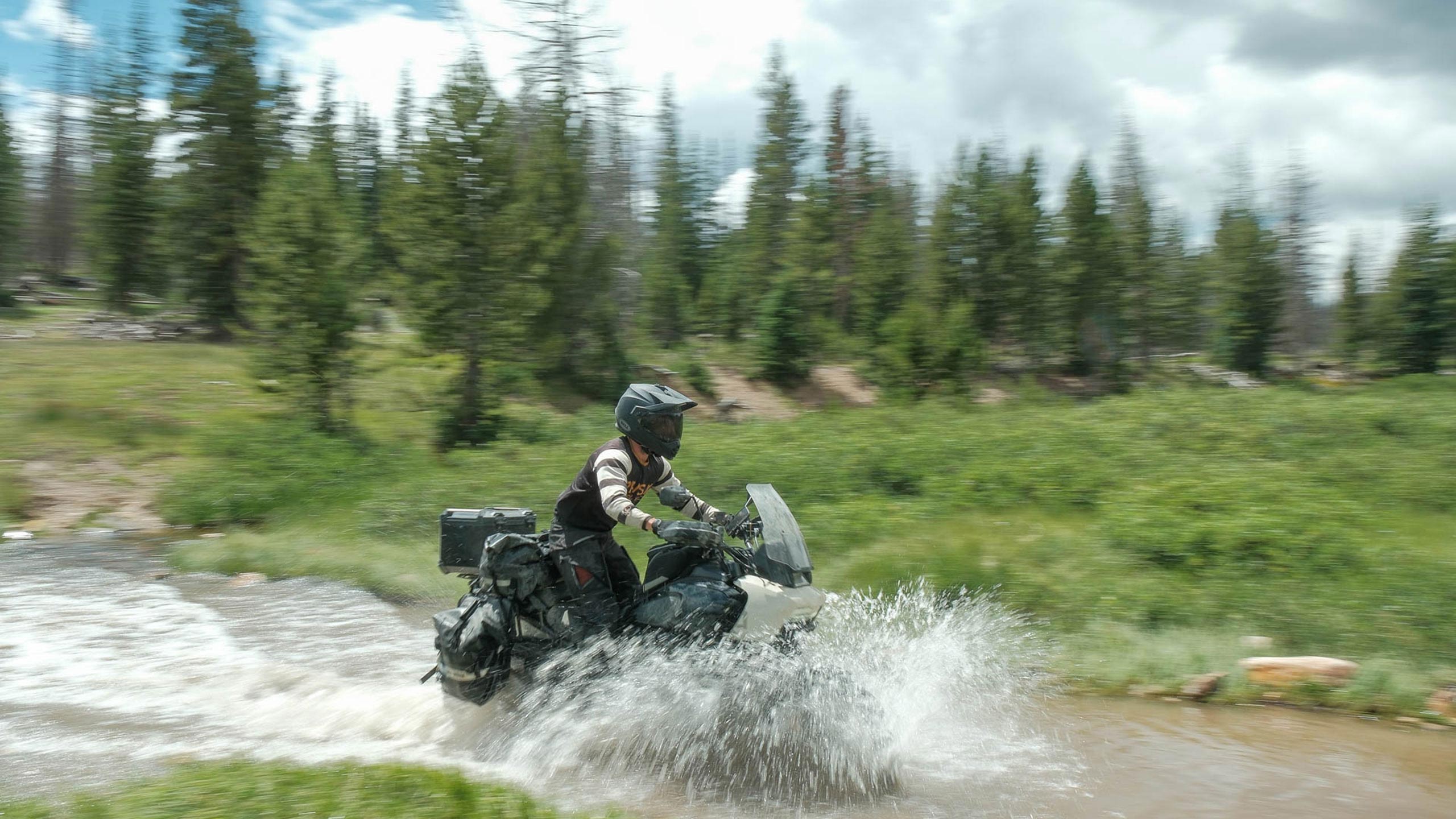 Rider riding his motorcycle through the river